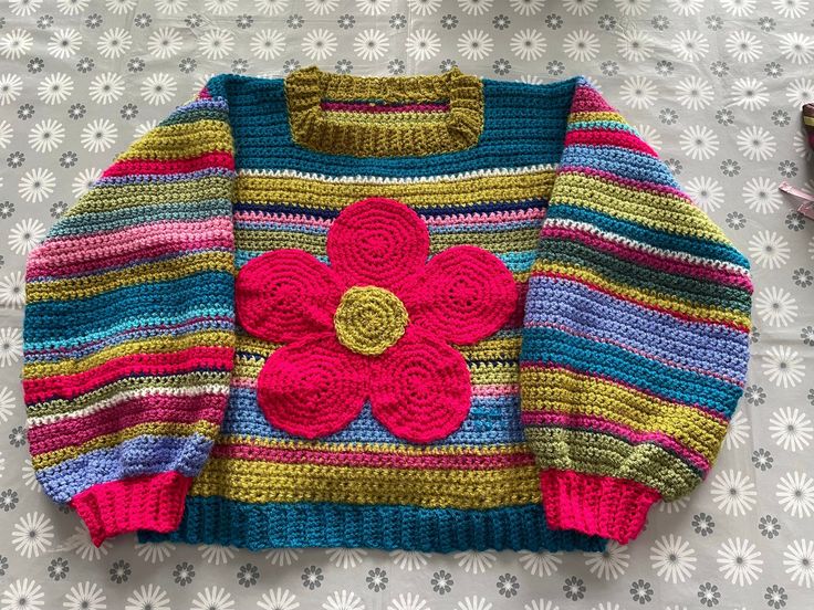 a crocheted sweater with a flower on it