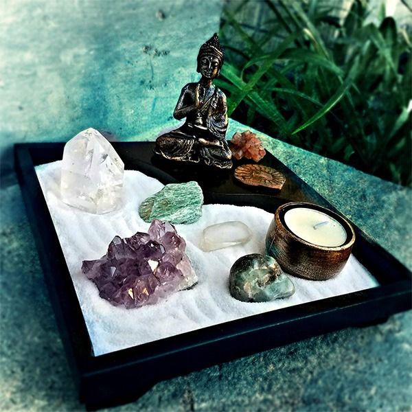 a tray with rocks and a buddha statue on it