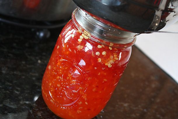 a jar filled with red sauce sitting on top of a counter