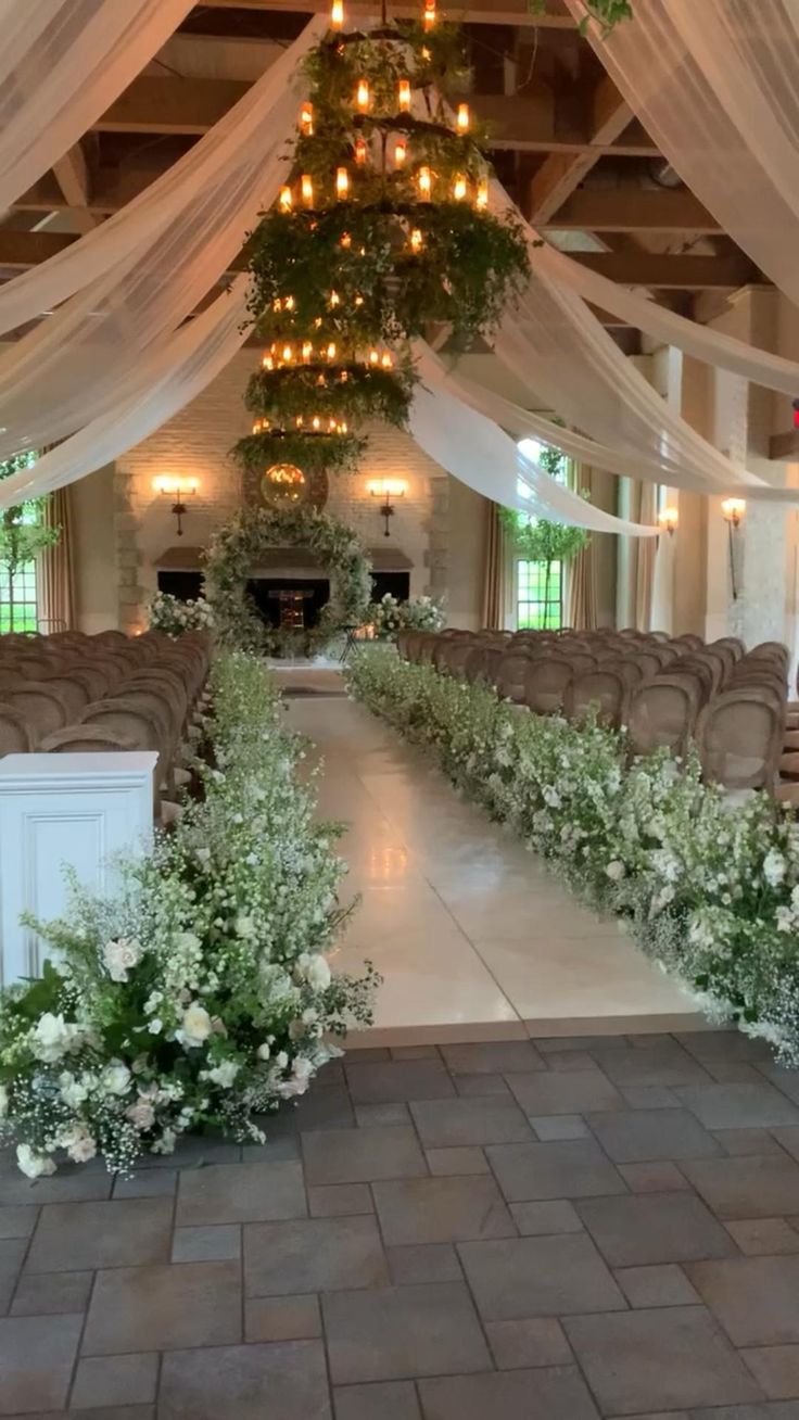 an indoor wedding venue decorated with white flowers and greenery