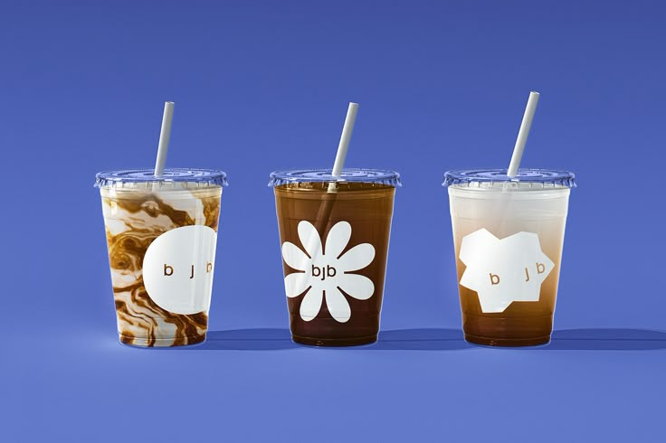 three different types of drinks with straws in them on a blue and white background