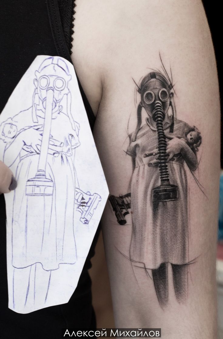 a woman with a gas mask on her arm holding a piece of paper next to a drawing