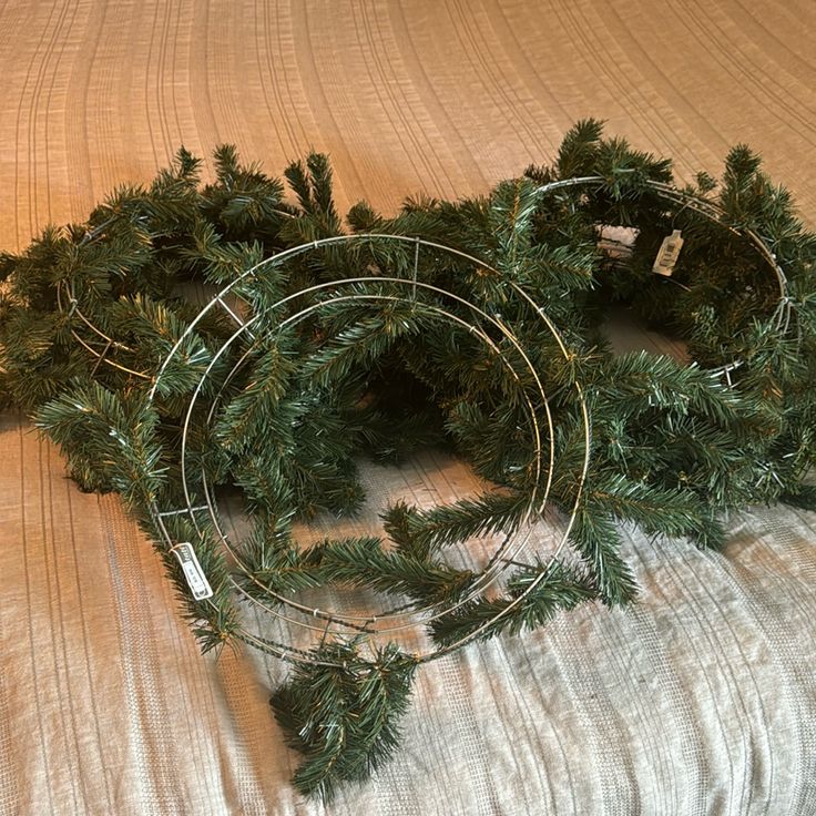 two wreaths sitting on top of a bed next to each other