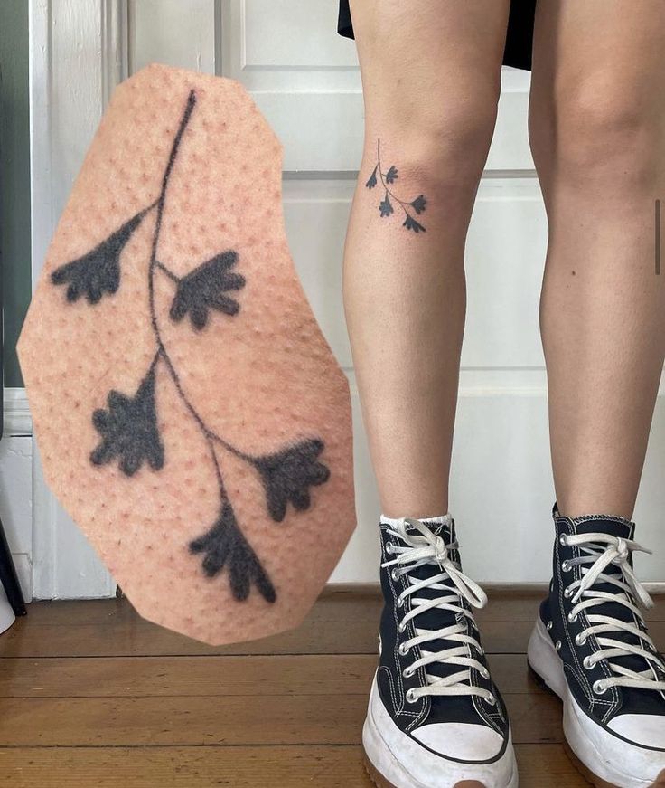 a woman's legs with tattoos on them next to an object that looks like a shoe