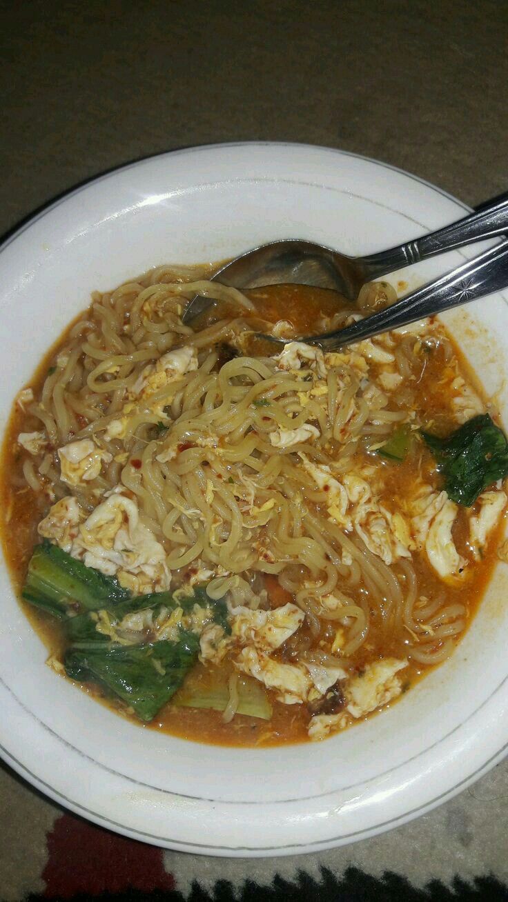 a white bowl filled with noodles and vegetables