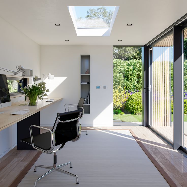 a modern home office with skylight and glass doors leading to the outside patio area