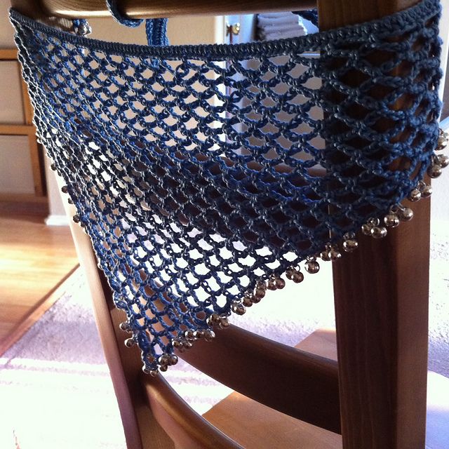 a close up of a wooden chair with a blue net on the back of it