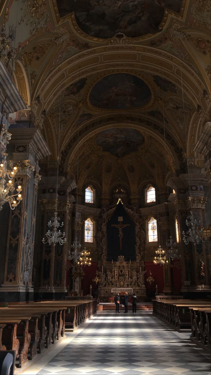 the inside of a large church with chandeliers and paintings on the walls,