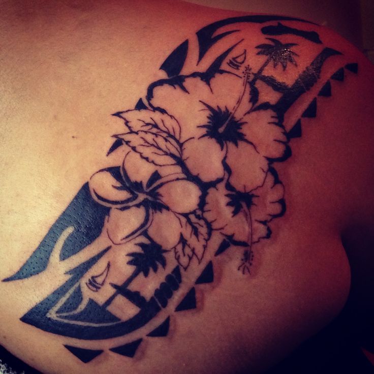 a woman's shoulder with flowers and a knife tattoo on her left side ribcage