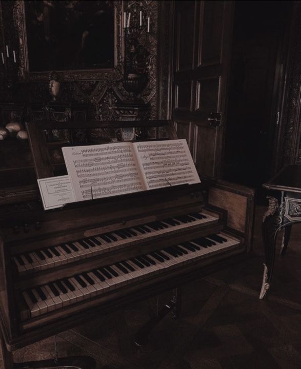 an old pipe organ with sheet music on it in a room filled with paintings and furniture