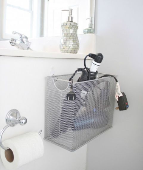 a bathroom with toilet paper and other items hanging on the wall next to a mirror