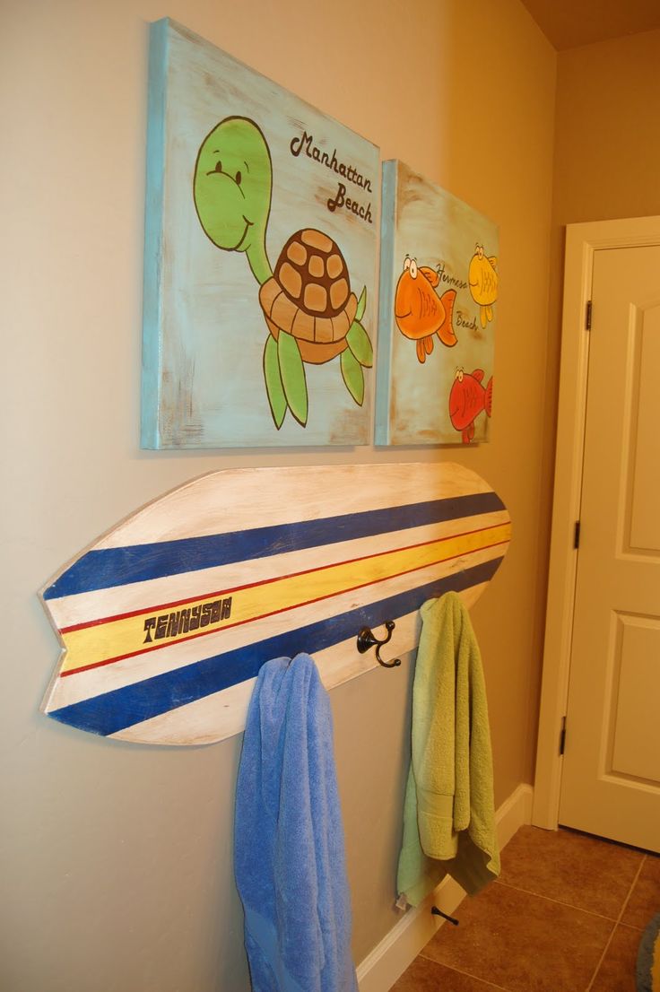 a surfboard mounted to the side of a wall next to a door and towel rack