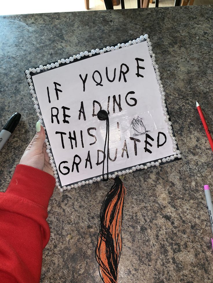 a graduation cap that says if you're reading this is graduated on the table