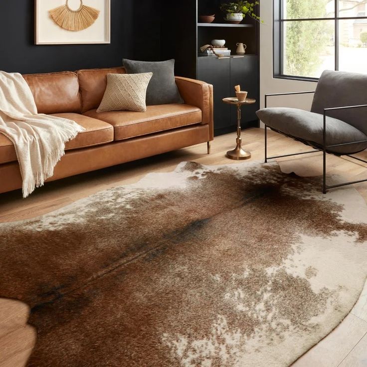 a living room filled with furniture and a brown rug on top of a hard wood floor