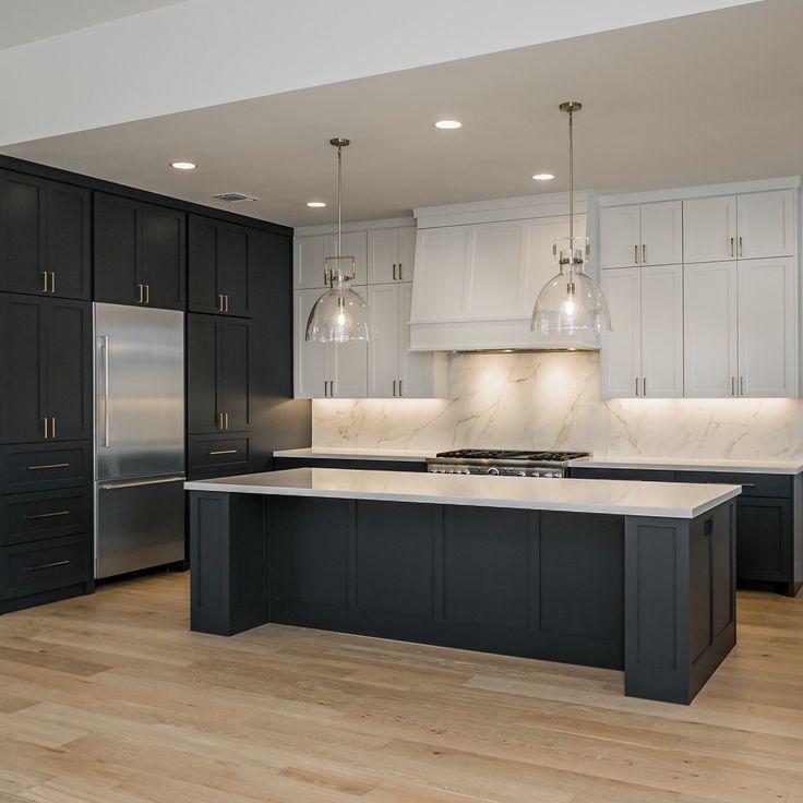 a large kitchen with black cabinets and white counter tops