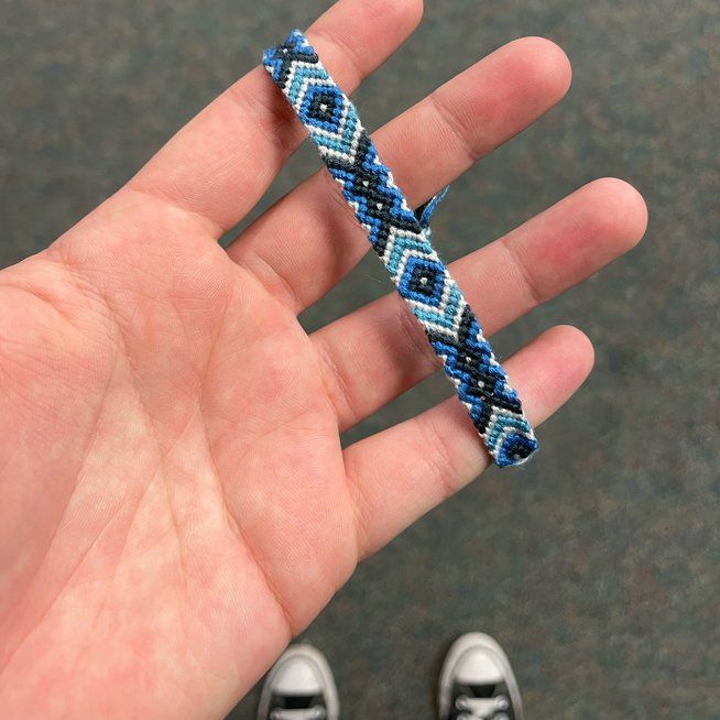 a hand holding a beaded bracelet in it's palm