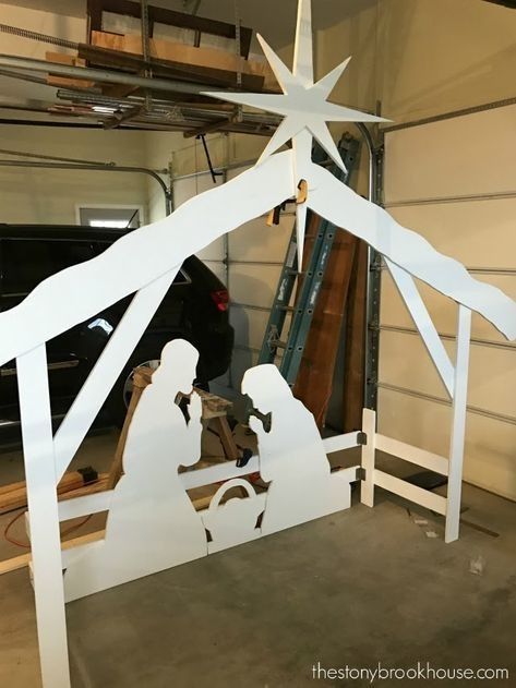 a nativity scene made out of white paper and wood with a star on top