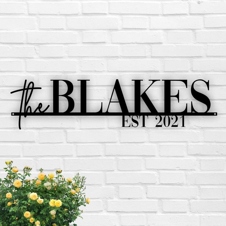 the blokes est 2021 sign on a white brick wall next to a potted plant