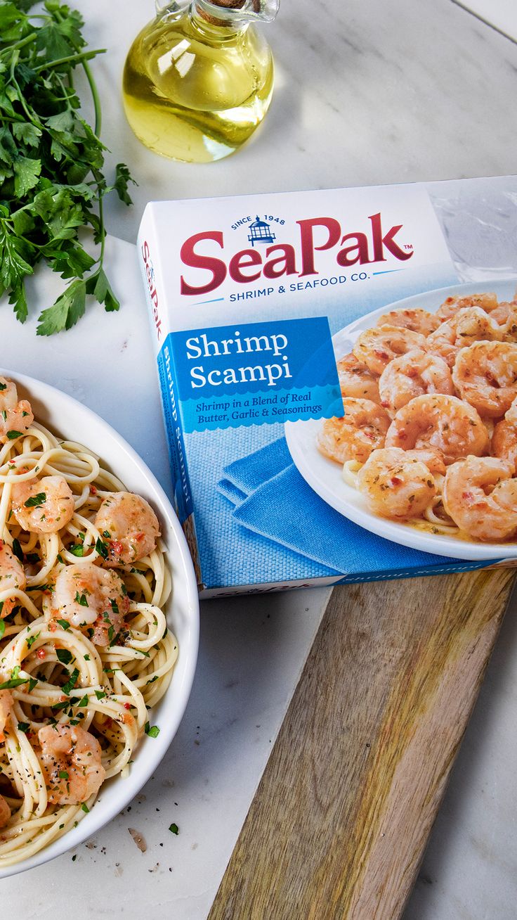 a box of sea pak shrimp scampi next to a bowl of pasta and parsley