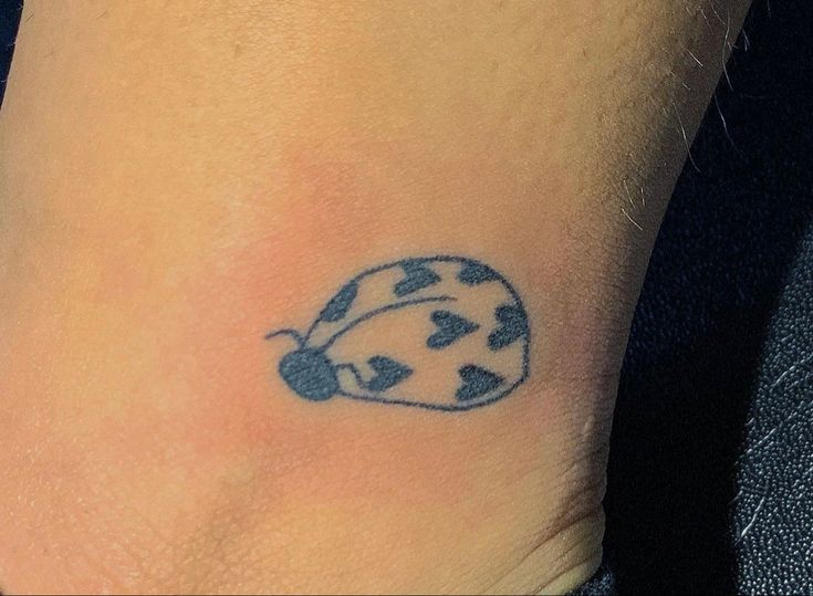 a ladybug tattoo on the ankle