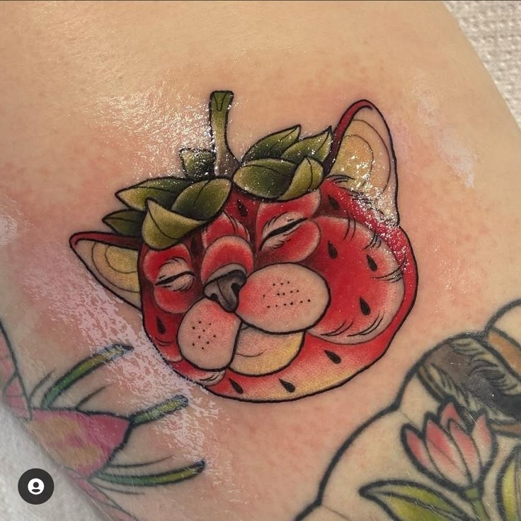 a close up of a person's leg with tattoos on it and an apple in the shape of a cat