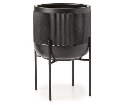 a black planter sitting on top of a metal stand