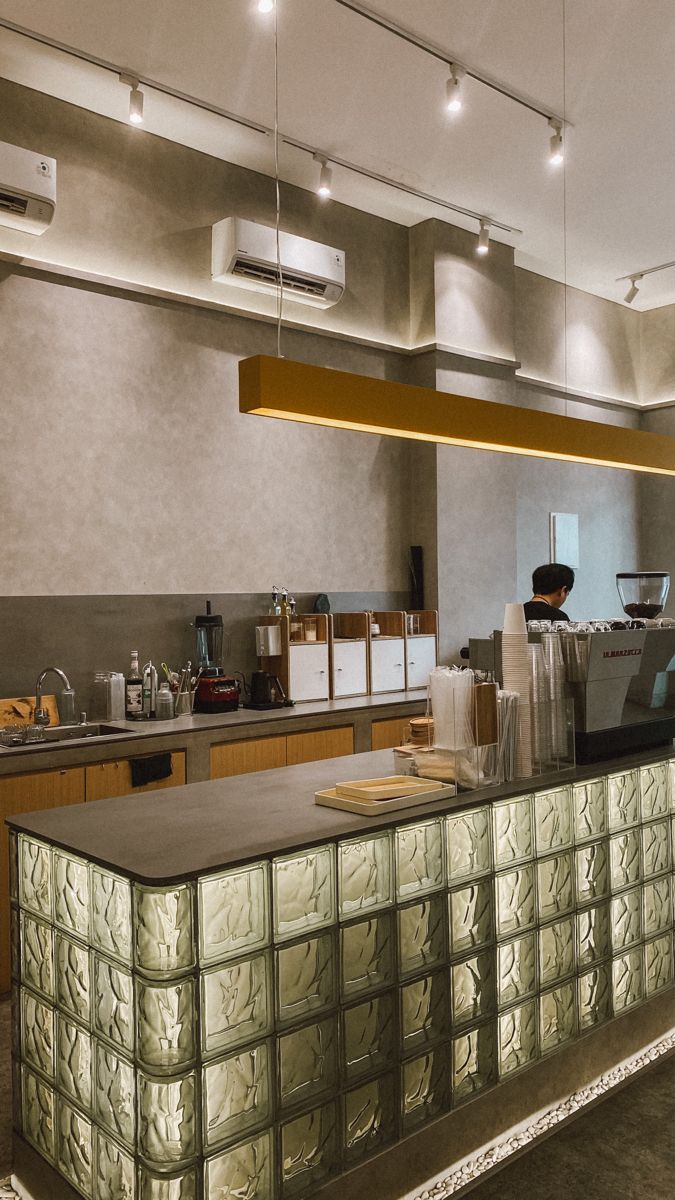 a large kitchen with lots of counter space and lights hanging from the ceiling above it