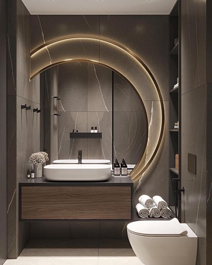 a modern bathroom with a circular mirror above the sink and toilet in front of it