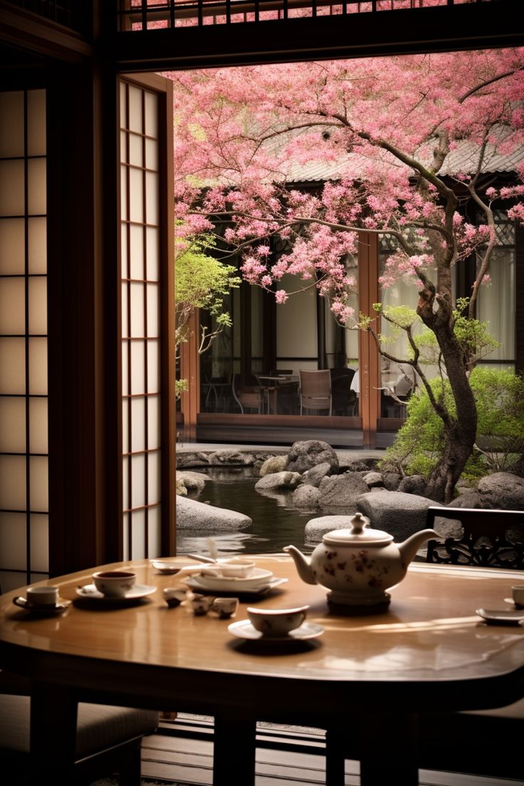 a table that has some food on it and a tree with pink flowers in the background