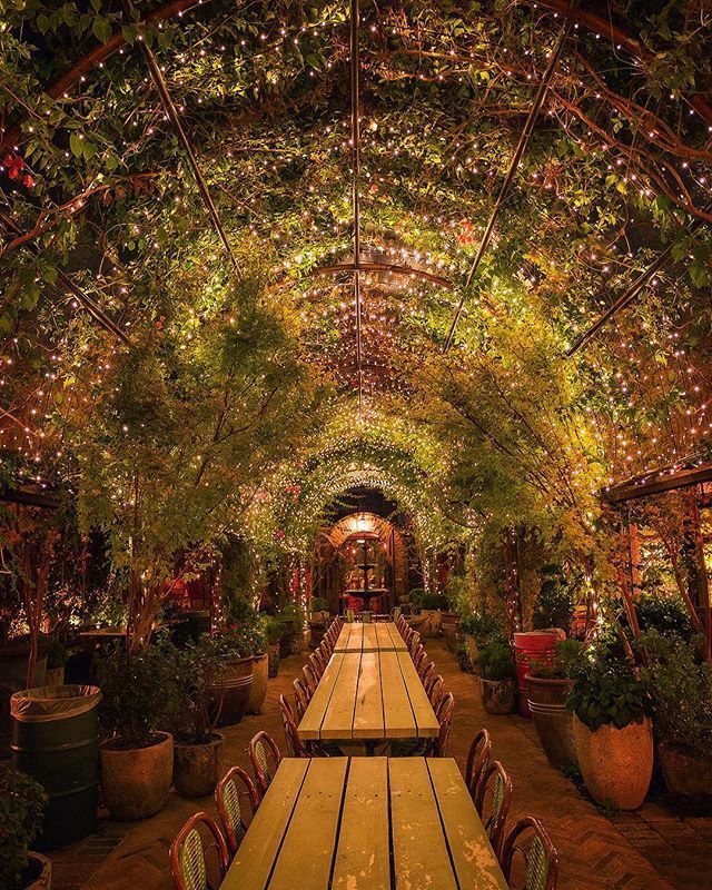 an outdoor dining area with tables and lights