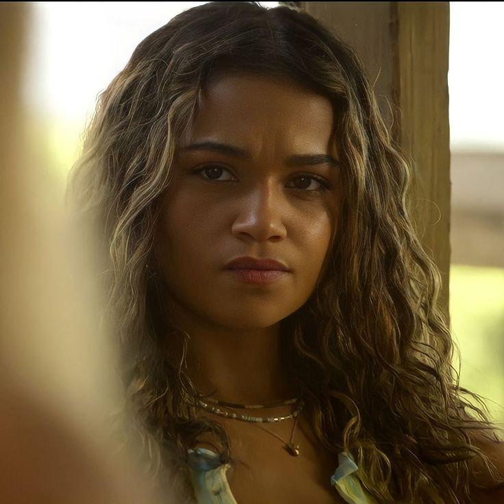 a close up of a person with long hair and wearing a necklace on her neck