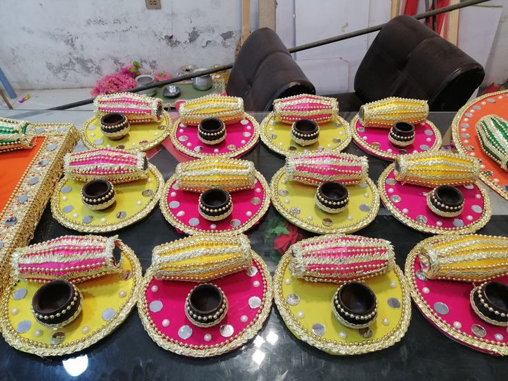 a table topped with lots of plates covered in different colored cloths and decorated with beads