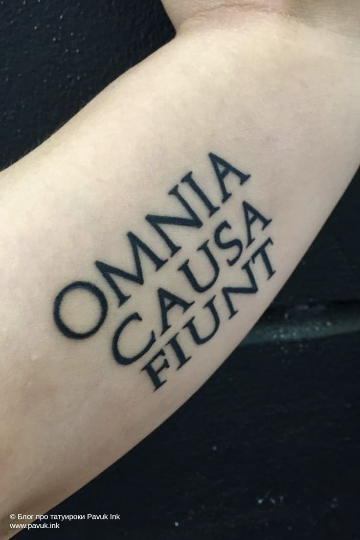 a person with a tattoo on their arm that reads, omnia causa flunt