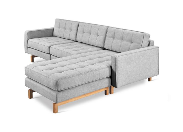 a gray couch and ottoman sitting next to each other