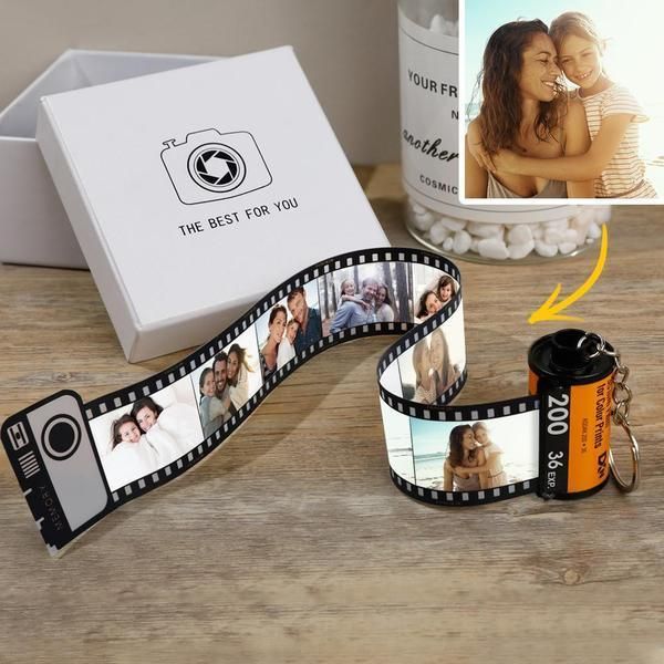 a camera and some pictures are sitting on a table next to an open gift box