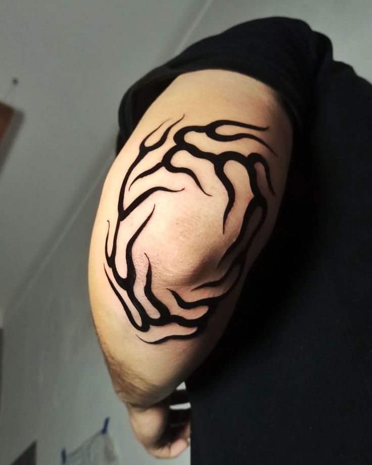 a man's arm with black ink on it and an abstract design in the middle