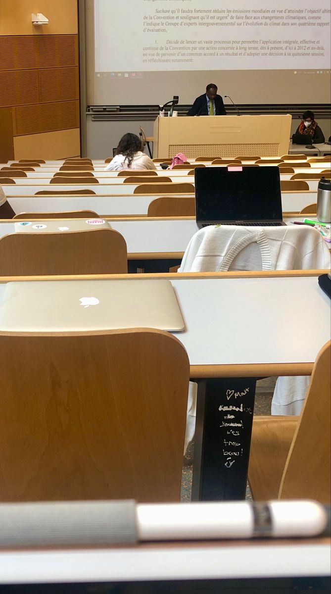 an empty classroom filled with desks and laptop computers