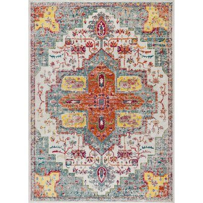 an orange, blue and yellow area rug with ornate designs on the bottom half of it