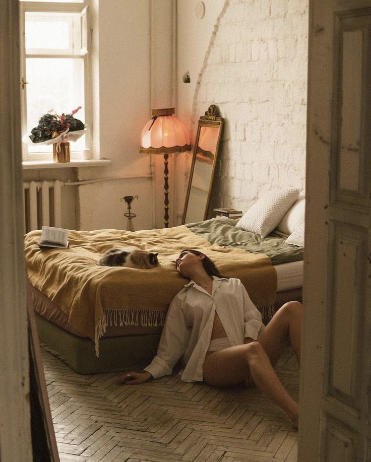 a woman laying on the floor in front of a bed