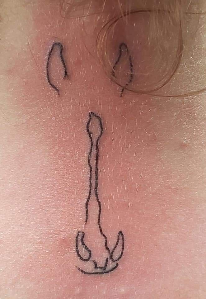 a tattoo on the back of a woman's neck that is drawn with black ink