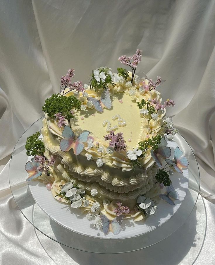 a cake with white frosting and butterflies on it