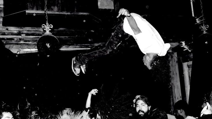 black and white photograph of people hanging upside down in the air at a party or event