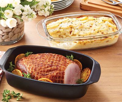 an advertisement for a baked dish with meat and vegetables on the table next to it