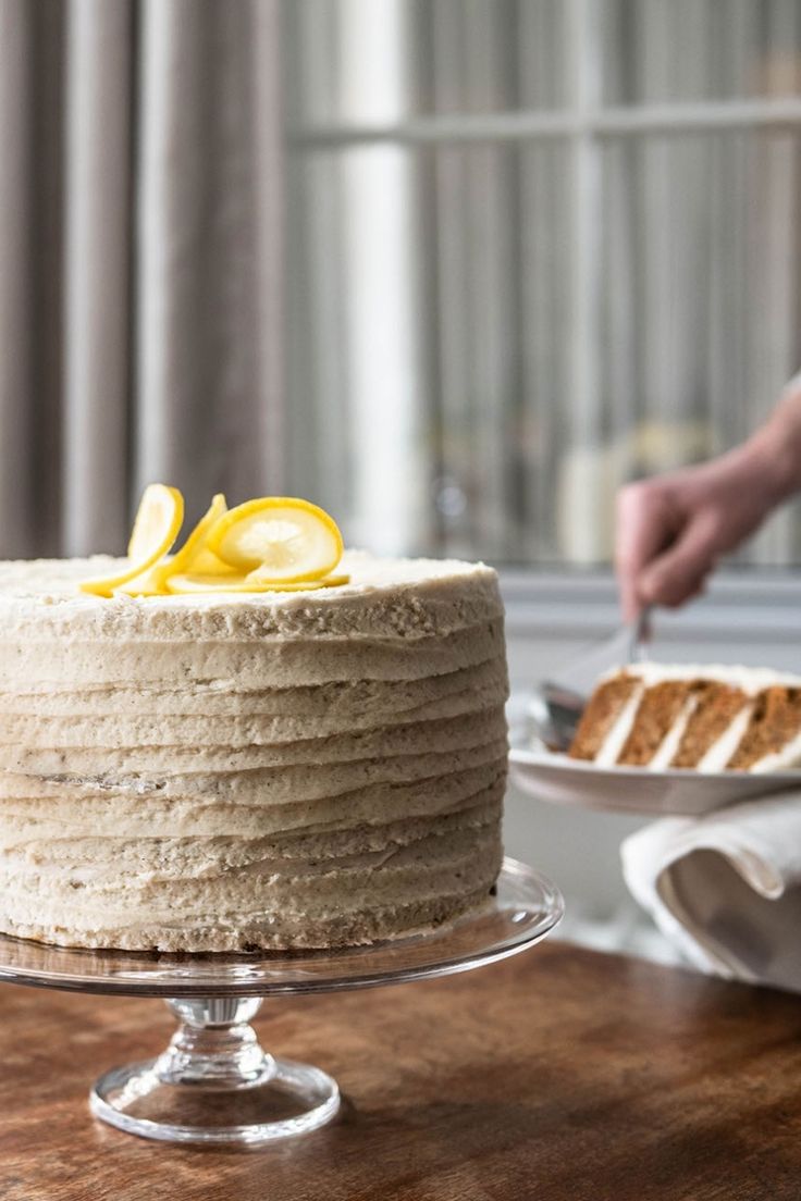 a person cutting into a cake on top of a wooden table