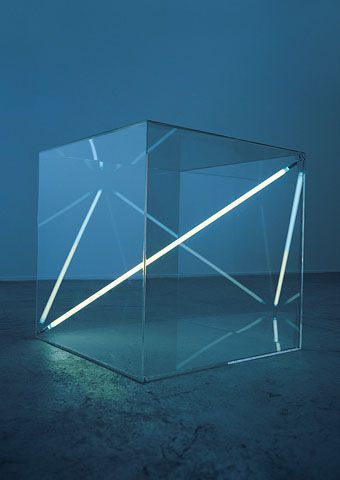 an illuminated cube sitting in the middle of a dark room with no one around it