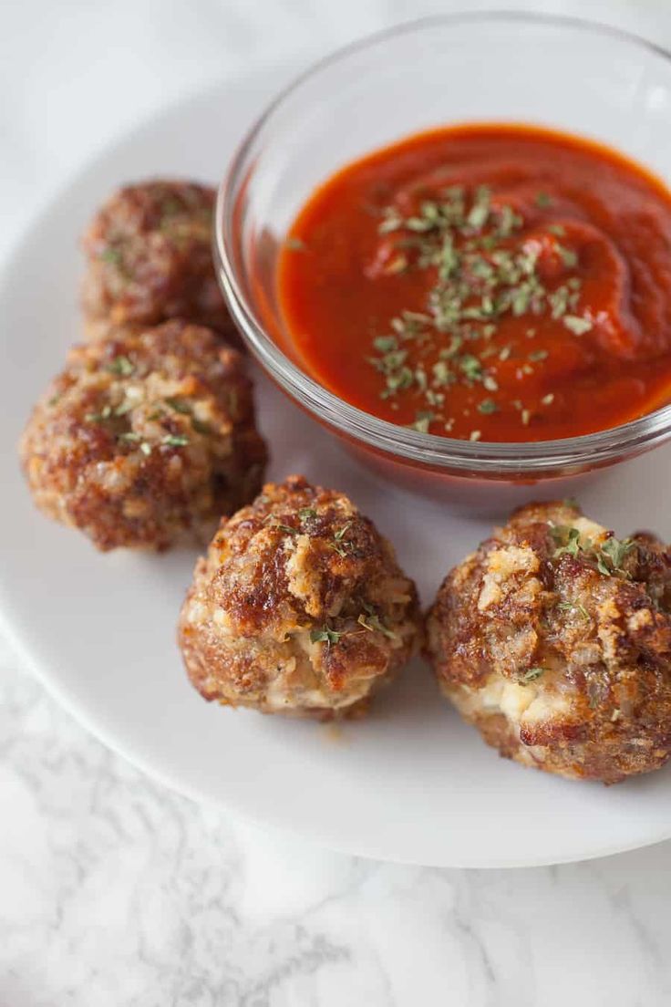 some meatballs are on a plate with sauce