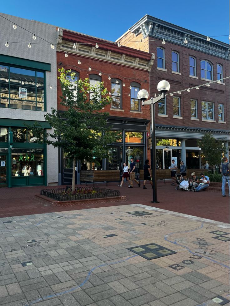 people are walking on the sidewalk in front of shops