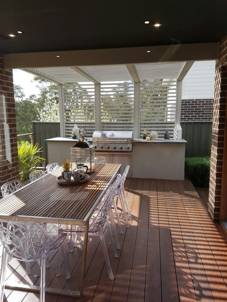 an outdoor kitchen and dining area on a deck with sun shining through the roof windows