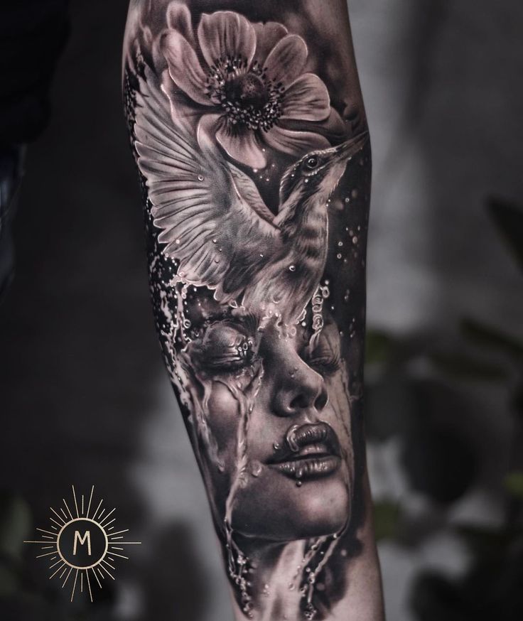 a woman's arm with an artistic tattoo design on it and flowers in the background