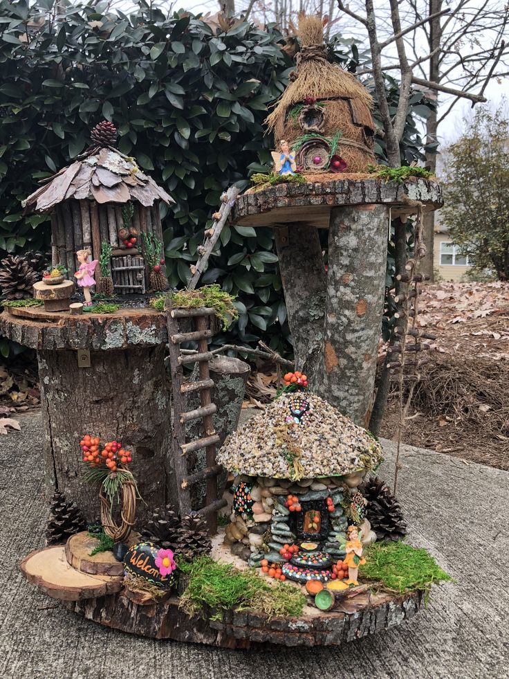 a tree stump with some little fairy houses on it